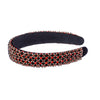 Black headband with red and gold embellishments on a white background