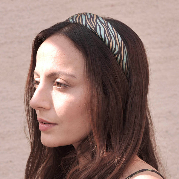 Woman wearing a patterned headband against a neutral background