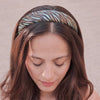 Woman wearing a patterned headband against a neutral background