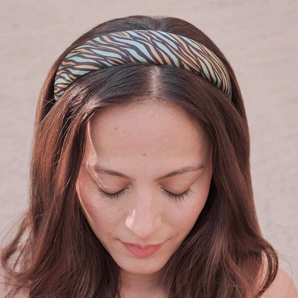 Woman wearing a patterned headband against a neutral background