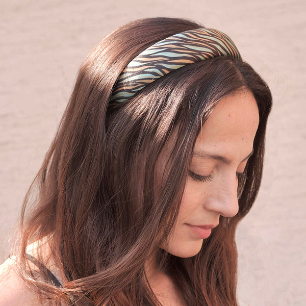 Woman wearing a patterned headband against a neutral background