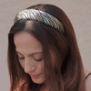 Woman wearing a patterned headband against a neutral background