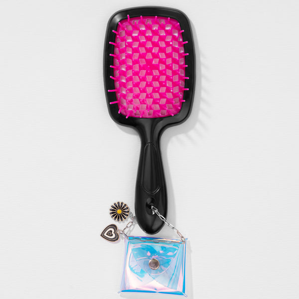 Black hairbrush with pink bristle head and decorative charm on a white background