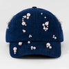 Blue cap with pearl embellishments on a light gray background
