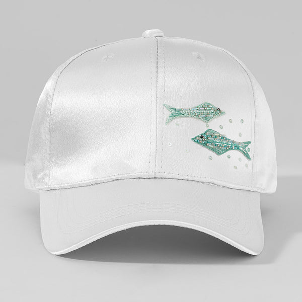 White cap with green fish designs on a gray background