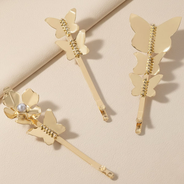Gold butterfly hair pins on a beige background