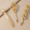 Gold hair accessories with intricate designs on a beige background