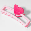 Pink hair clip with heart-shaped end on a white background
