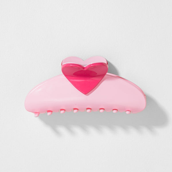 Pink heart-shaped hair clip on a light gray background