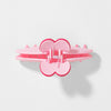 Pink heart-shaped hair clip on a light gray background