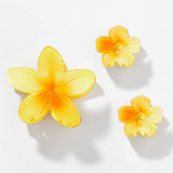 Three yellow flower-shaped objects on a white background