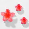 Three pink floral earrings on a light gray background