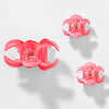 Pink hair clips with a distinctive design on a white background
