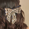 Decorative hair clip with crystals on a person's hair against a neutral background