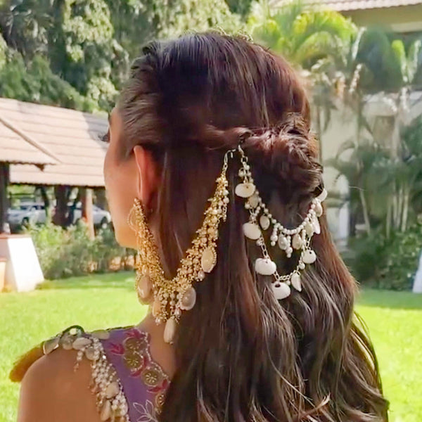 Woman with elaborate hair and jewelry in a garden setting
