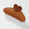 Brown hair clip with a heart-shaped end on a white background