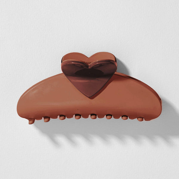 Brown heart-shaped hair clip on a light gray background