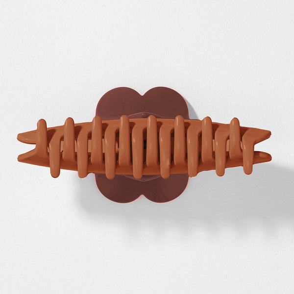 Brown hair clip on a light gray background