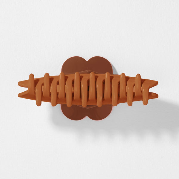 Brown hair clip on a light gray background