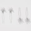 Set of four silver hairpins with floral designs on a light gray background