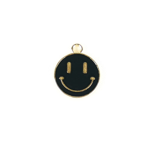 A small metal charm featuring a black smiley face with gold-colored accents and details.