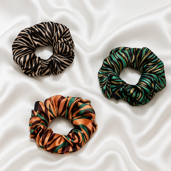 Three patterned scrunchies on a white fabric background