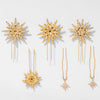 Set of gold star-shaped hairpins on a light gray background