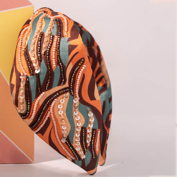 Decorative headband with colorful pattern and beads on a white background