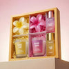 Set of scented candles and a bottle of perfume in a decorative box with floral designs.