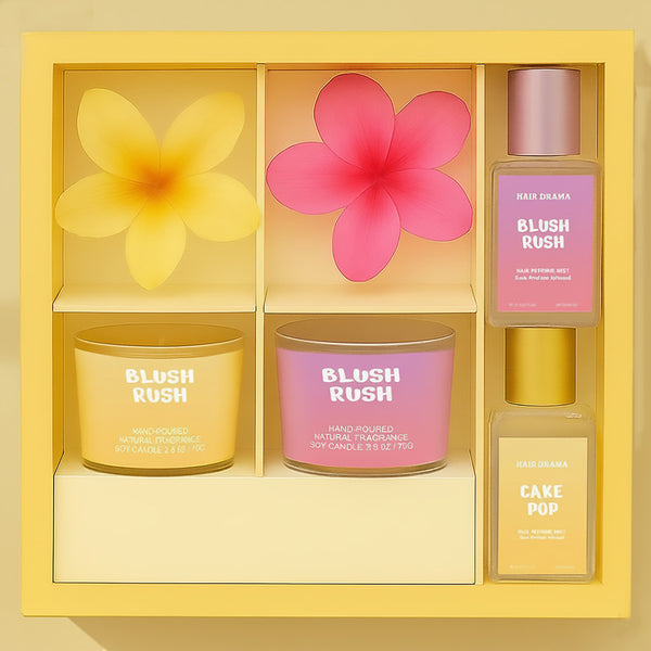 Set of scented candles and a bottle of perfume in a decorative box with floral designs.