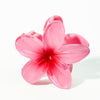 Pink flower-shaped hair clip on a white background