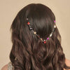 Hair accessory with beads on a person with wavy hair against a beige background