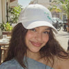 Lightweight white satin cap with blue sardine motifs adding a whimsical seaside touch
