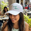 Chic white satin cap featuring blue fish embroidery, perfect for beach days and brunches