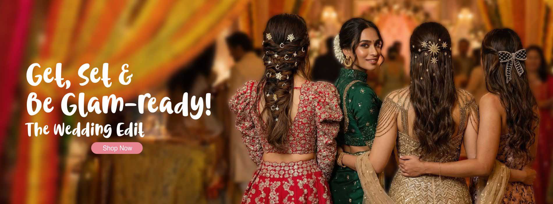 Three women in traditional outfits with decorative hair accessories at a wedding event.