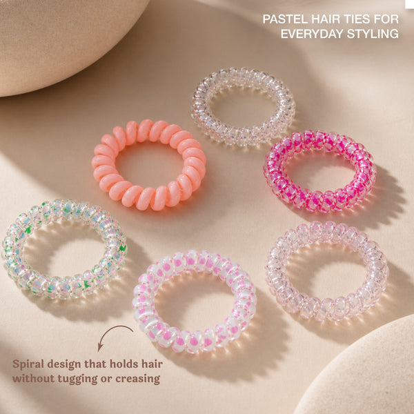 Set of colorful beaded hair ties on a textured beige surface with dried flowers.