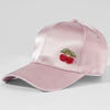 Pink satin cap with cherry embroidery on a light gray background