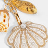 Decorative keychain with shell and pearl design on a light background