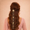 Long wavy hair with a decorative hair accessory on a pink background
