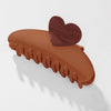 Brown hair clip with a heart-shaped end on a white background