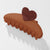 Brown hair clip with a heart-shaped end on a white background