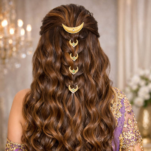 Woman with long, wavy hair adorned with gold hair accessories in a luxurious setting.