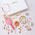 Collection of hair accessories including a pink brush, scrunchies, and decorative hair ties on a white surface with 'Hair Drama Co' branding.