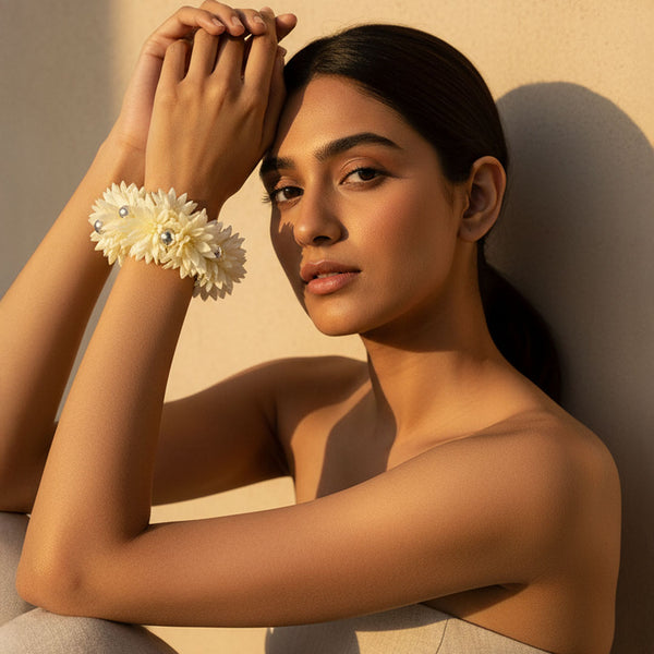 Woman wearing a floral bracelet against a warm-toned background