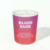 Candle with 'Blush Rush' text on a gradient purple and pink container