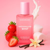 Bottle of 'Hair Drama Marshmallow Whip' hair perfume mist with strawberries, marshmallows, and vanilla beans on a pink background.